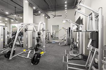 A gym with a variety of equipment including weight machines and free weights.
